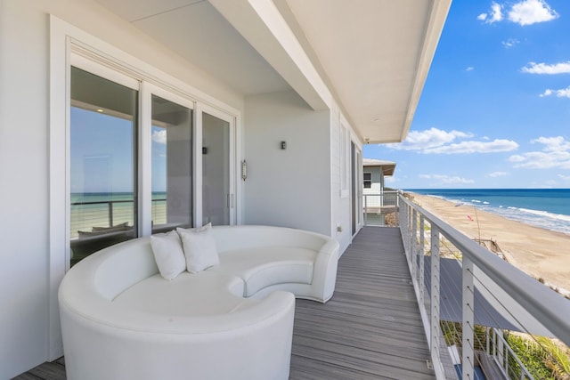 balcony featuring a view of the beach and a water view