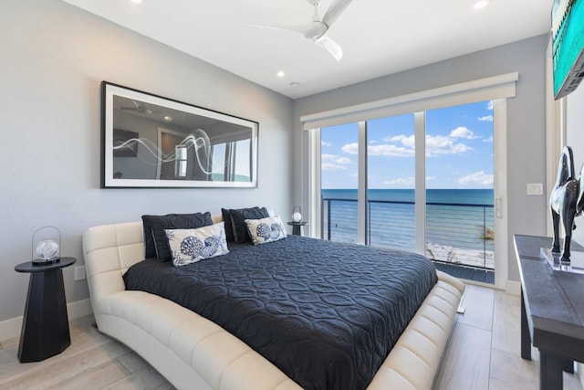 bedroom featuring a ceiling fan, wood finished floors, baseboards, a water view, and access to outside