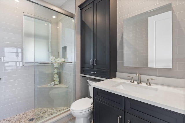 bathroom featuring a tile shower, toilet, and vanity