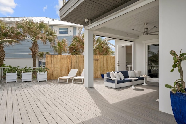 wooden deck featuring a ceiling fan, an outdoor living space, and fence