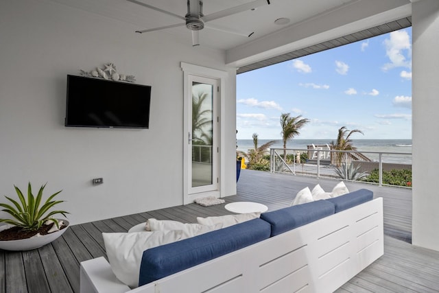 deck featuring outdoor lounge area, a ceiling fan, and a water view