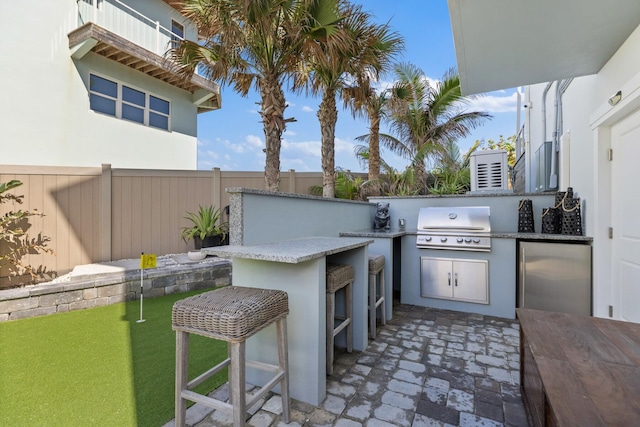 view of patio with area for grilling and fence