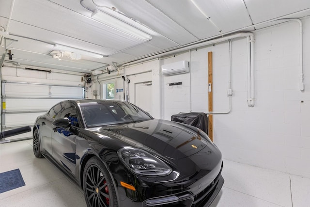 garage featuring concrete block wall and a wall mounted AC