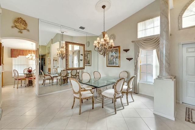 tiled dining room with high vaulted ceiling and a notable chandelier