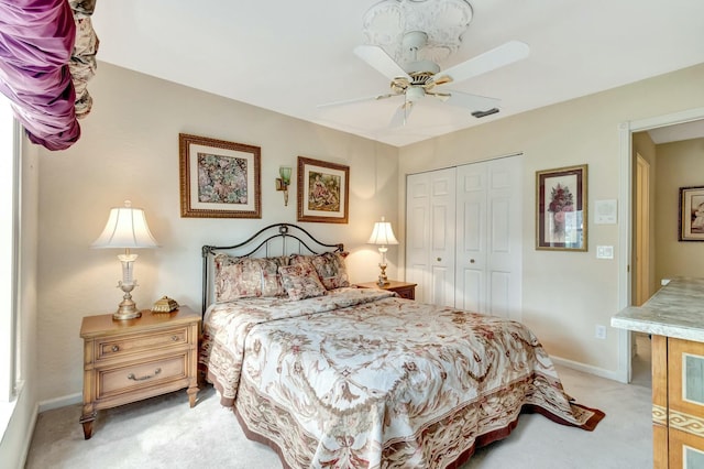 carpeted bedroom featuring ceiling fan and a closet