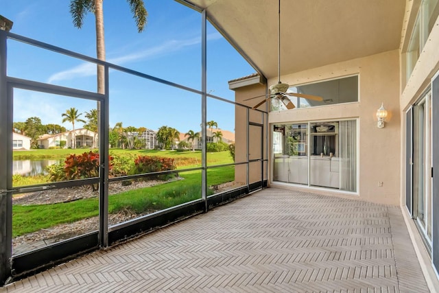 unfurnished sunroom with a water view and ceiling fan