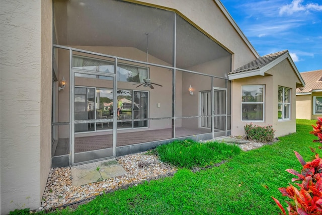 back of property with a lawn and ceiling fan