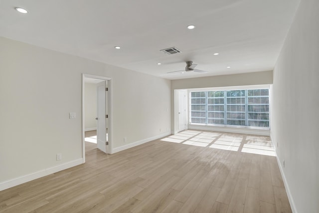 empty room with ceiling fan and light hardwood / wood-style flooring