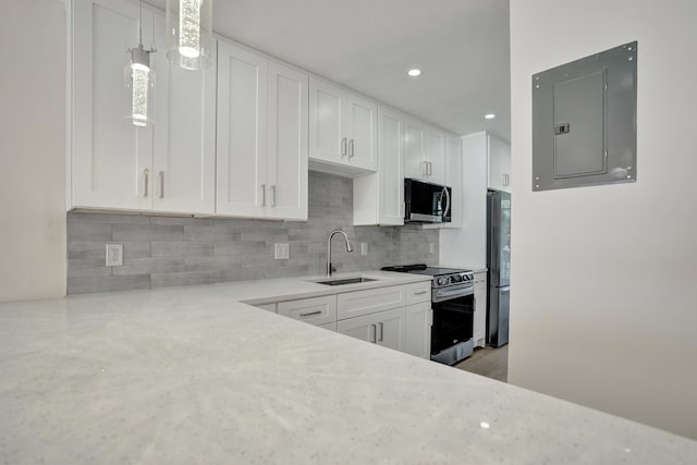 kitchen with sink, stainless steel range with electric cooktop, electric panel, pendant lighting, and white cabinets