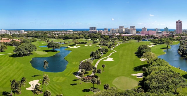 drone / aerial view featuring a view of city, view of golf course, and a water view