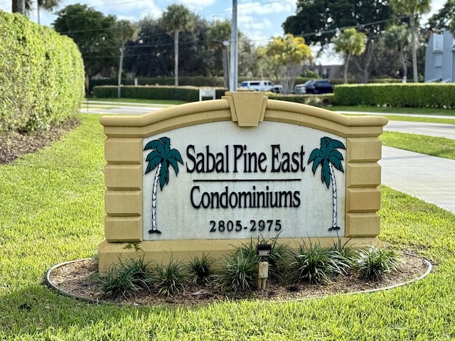 community / neighborhood sign featuring a yard