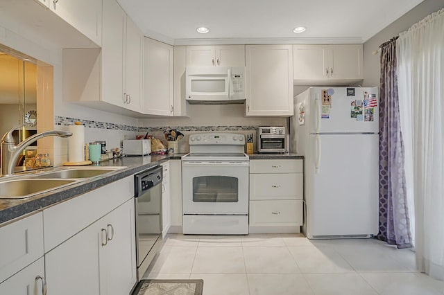 kitchen with tasteful backsplash, white appliances, sink, and white cabinets