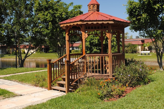 view of community featuring a lawn, a playground, and a water view