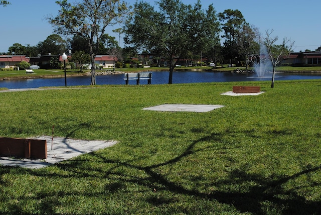 view of community featuring a water view and a lawn