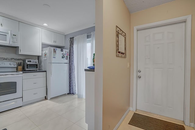 kitchen featuring light tile patterned flooring, white cabinets, white appliances, and decorative backsplash