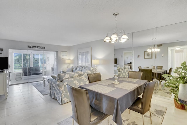 dining area with an inviting chandelier, a textured ceiling, and light tile patterned floors