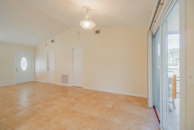 tiled empty room with vaulted ceiling