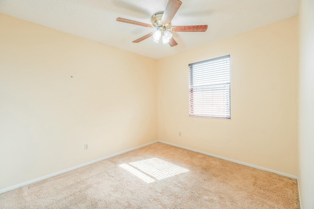 carpeted spare room featuring ceiling fan