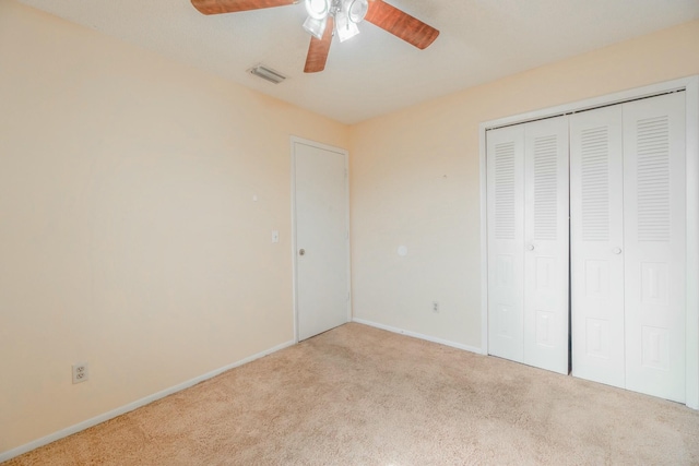 unfurnished bedroom with light carpet, a closet, and ceiling fan