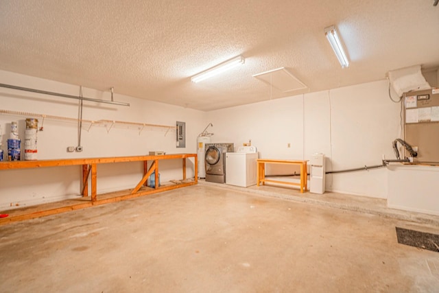 basement featuring a workshop area, washing machine and dryer, electric water heater, electric panel, and a textured ceiling