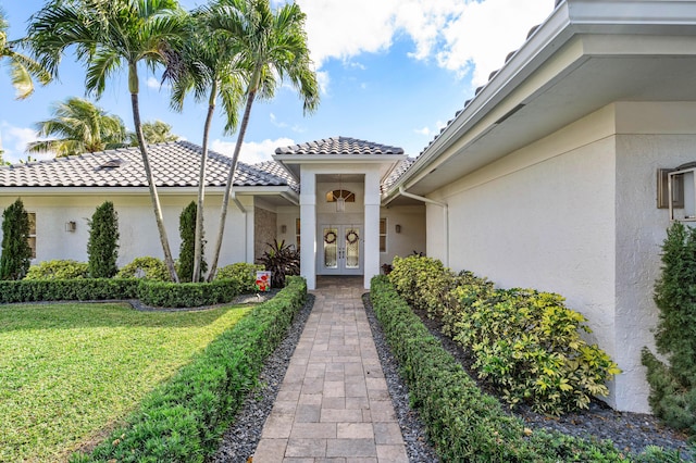 view of exterior entry with a lawn