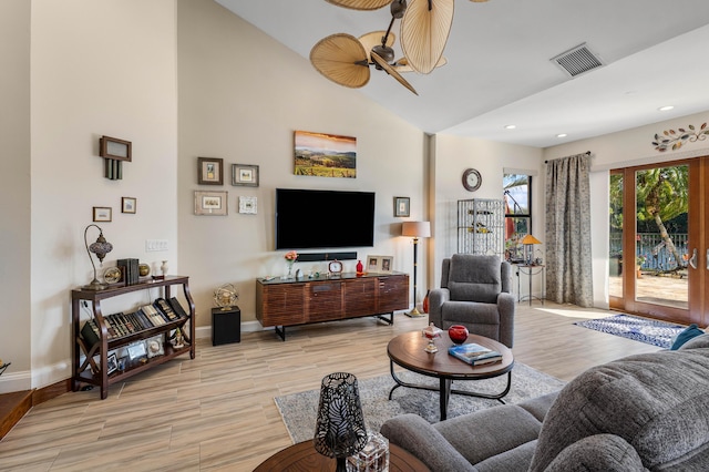 living room with light hardwood / wood-style flooring, high vaulted ceiling, and ceiling fan