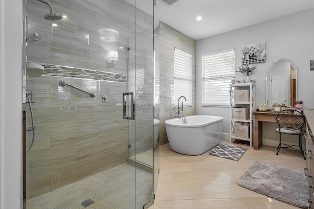 bathroom with tile patterned floors and separate shower and tub