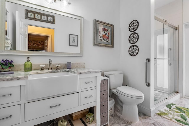 bathroom featuring vanity, toilet, and a shower with door