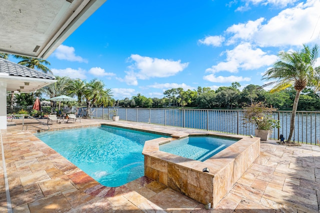 view of swimming pool with an in ground hot tub, a water view, and a patio