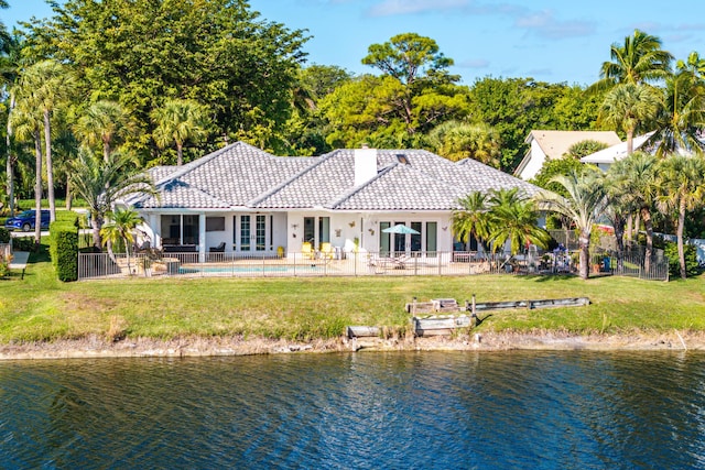 back of house featuring a water view, a yard, and french doors