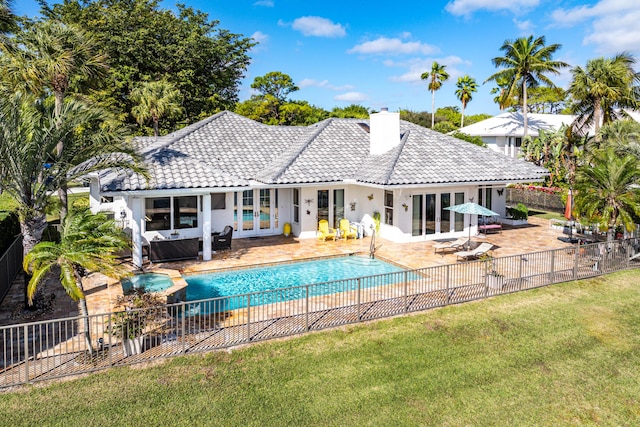 back of house with a fenced in pool, a patio, a yard, and french doors