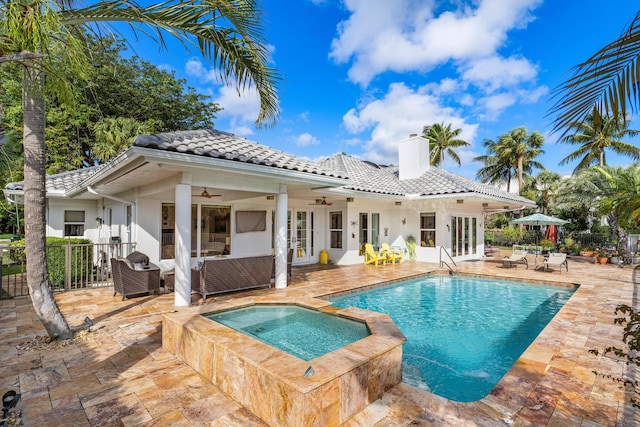 back of house with a patio, outdoor lounge area, a swimming pool with hot tub, ceiling fan, and french doors