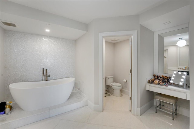 bathroom featuring vanity, toilet, a bathing tub, and tile patterned flooring