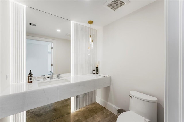 bathroom with sink, concrete flooring, and toilet