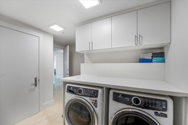 washroom with cabinets and washing machine and dryer