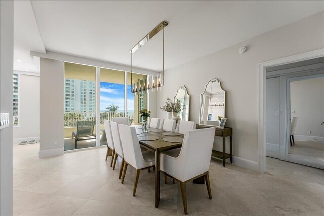 dining area featuring a wall of windows and a notable chandelier