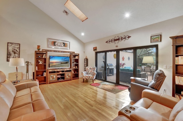 living room with hardwood / wood-style floors and high vaulted ceiling