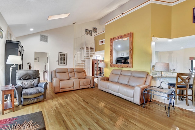 living room with hardwood / wood-style flooring and high vaulted ceiling