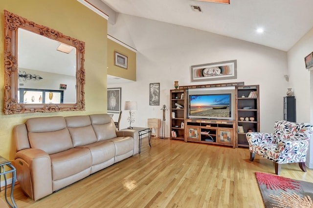 living room featuring high vaulted ceiling and light hardwood / wood-style flooring