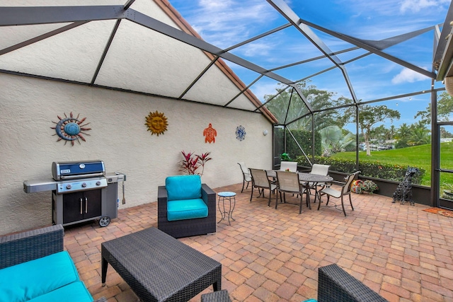 view of patio with area for grilling and a lanai