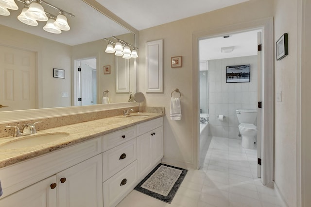 bathroom with a washtub, vanity, tile patterned flooring, and toilet