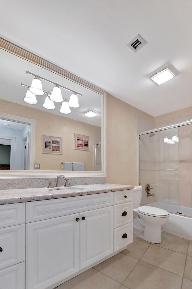 full bathroom featuring vanity, tile patterned flooring, shower / bath combination with glass door, and toilet