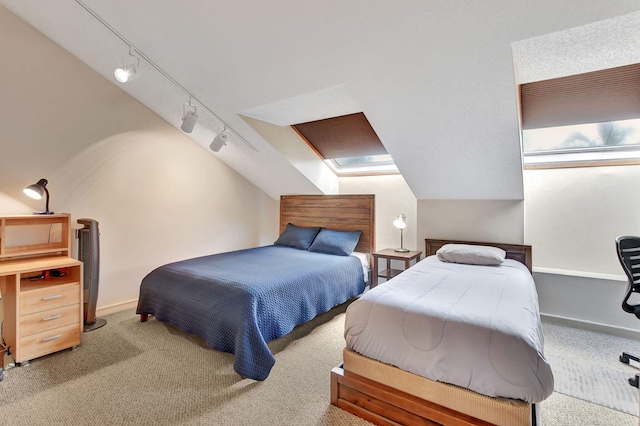 carpeted bedroom featuring lofted ceiling and rail lighting