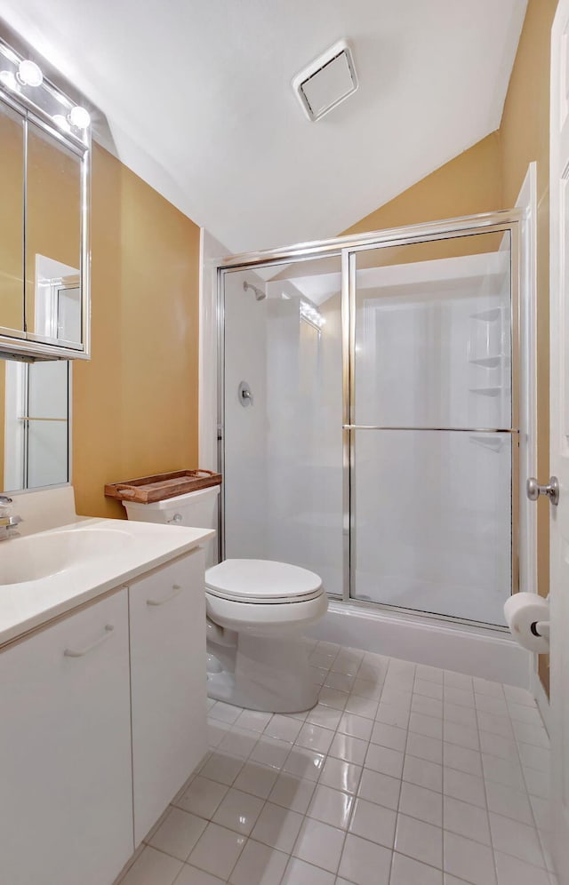 bathroom with lofted ceiling, toilet, a shower with shower door, tile patterned floors, and vanity