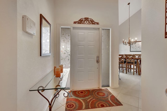 tiled foyer with a chandelier