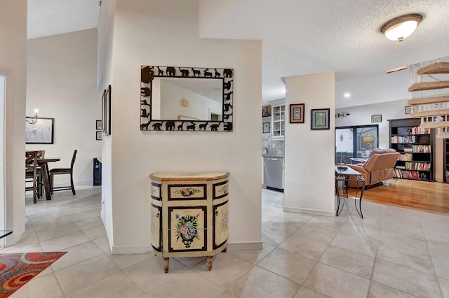 hallway with tile patterned flooring and a textured ceiling