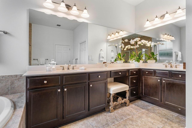 bathroom featuring vanity, tiled tub, and tile patterned floors