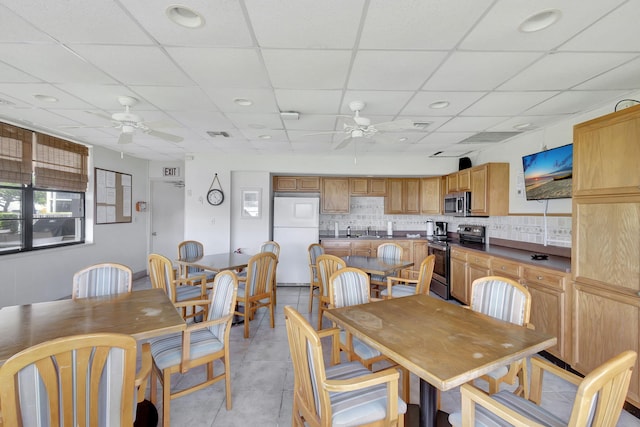 tiled dining room featuring ceiling fan and a paneled ceiling