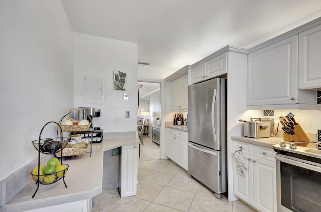 kitchen with light tile patterned flooring, appliances with stainless steel finishes, white cabinets, and electric panel