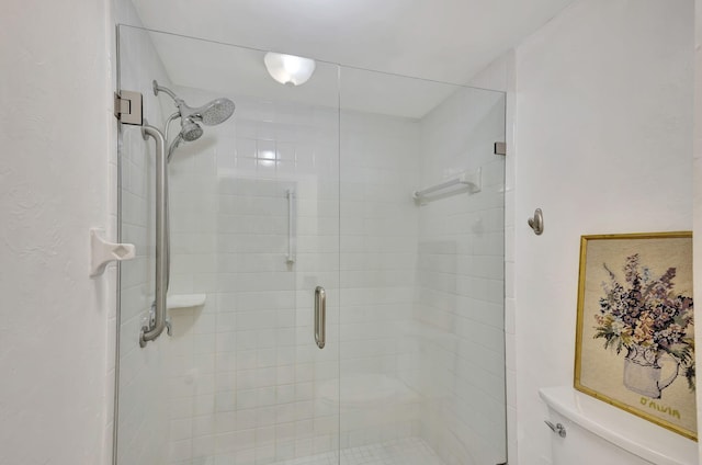 bathroom with an enclosed shower and toilet